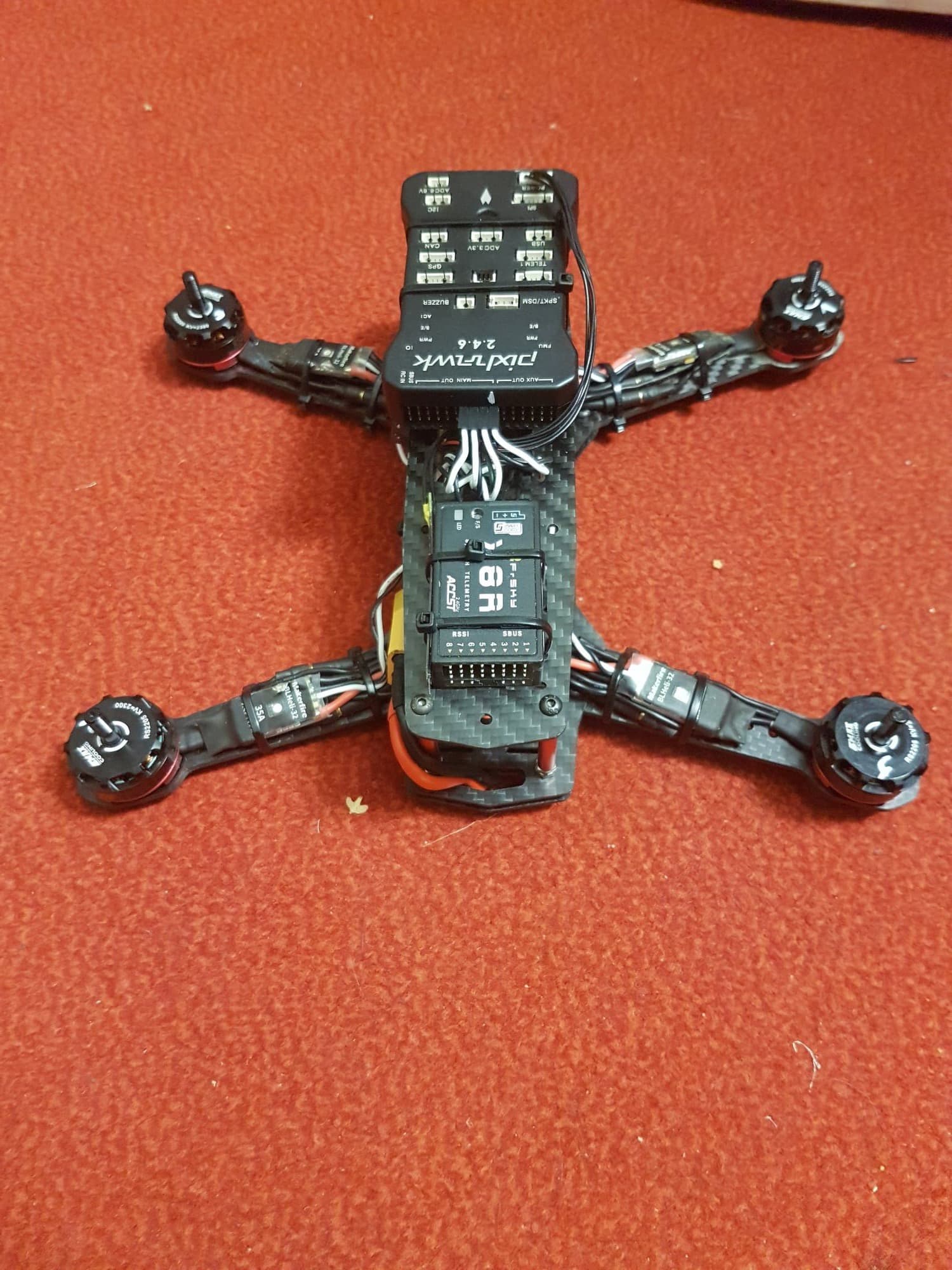 Racing drone underside — carbon frame, ESCs, flight controller