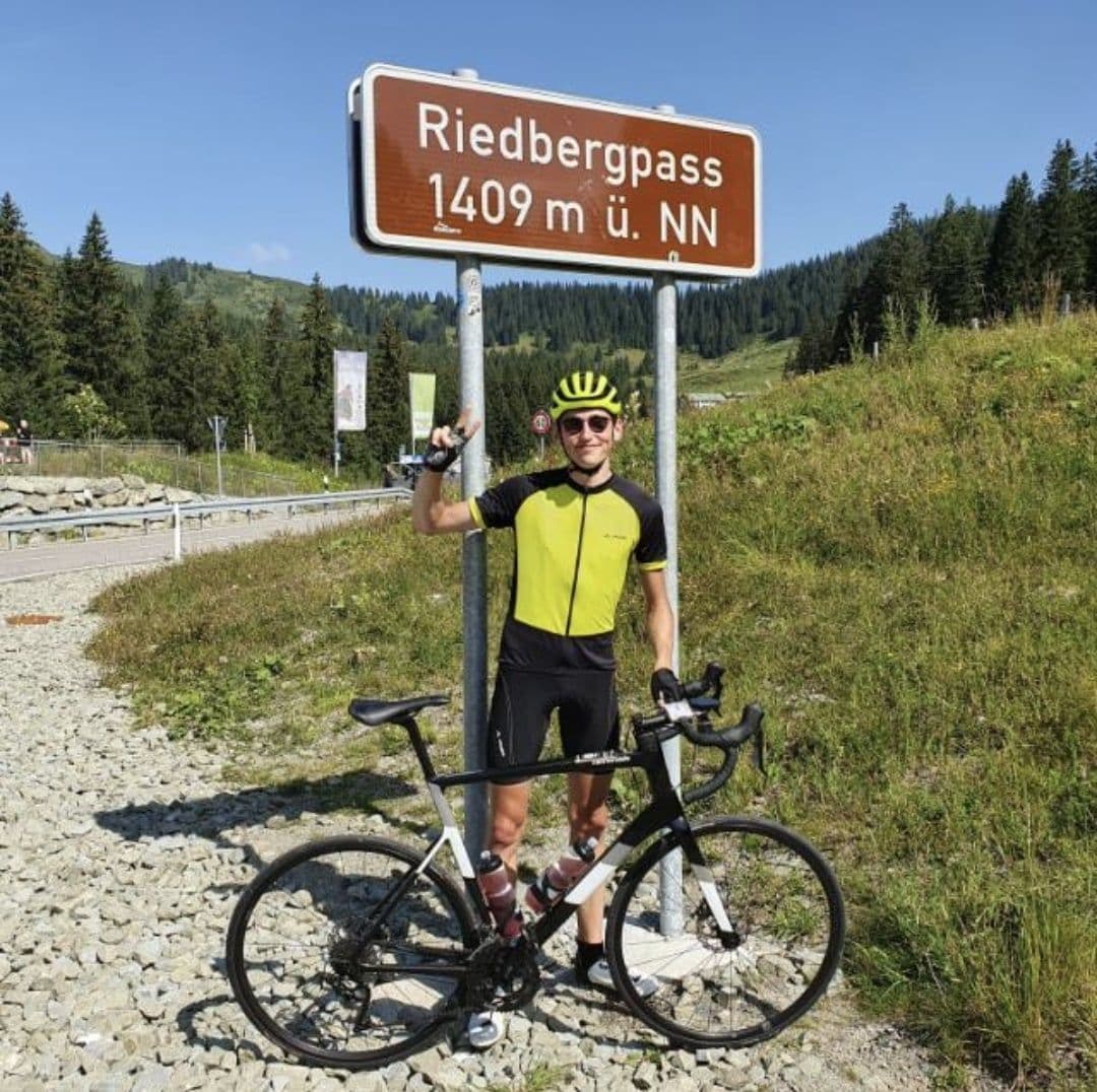 Julian at Riedbergpass 1409m sign, yellow jersey