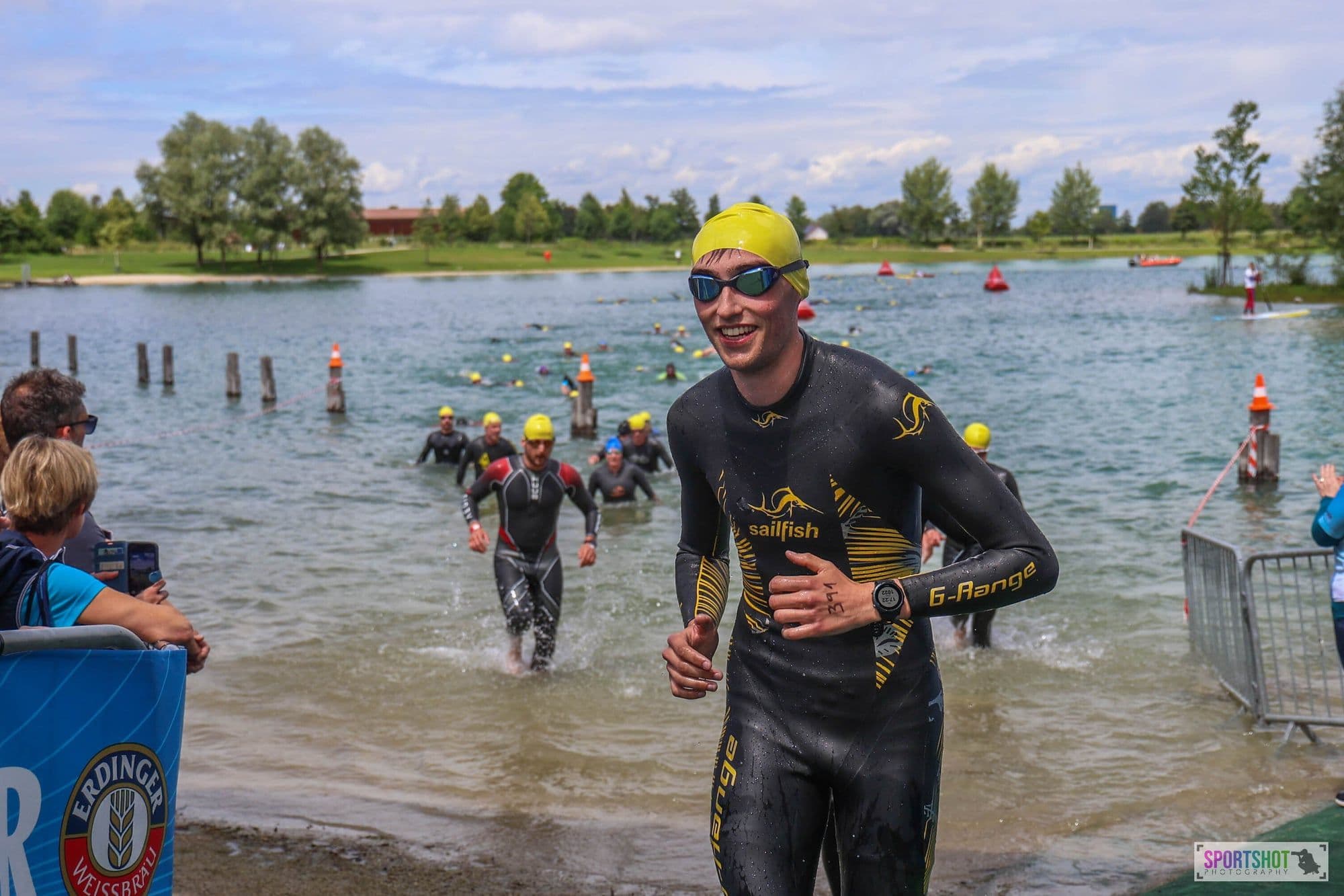 Julian exiting water in Sailfish wetsuit, Erdinger banner