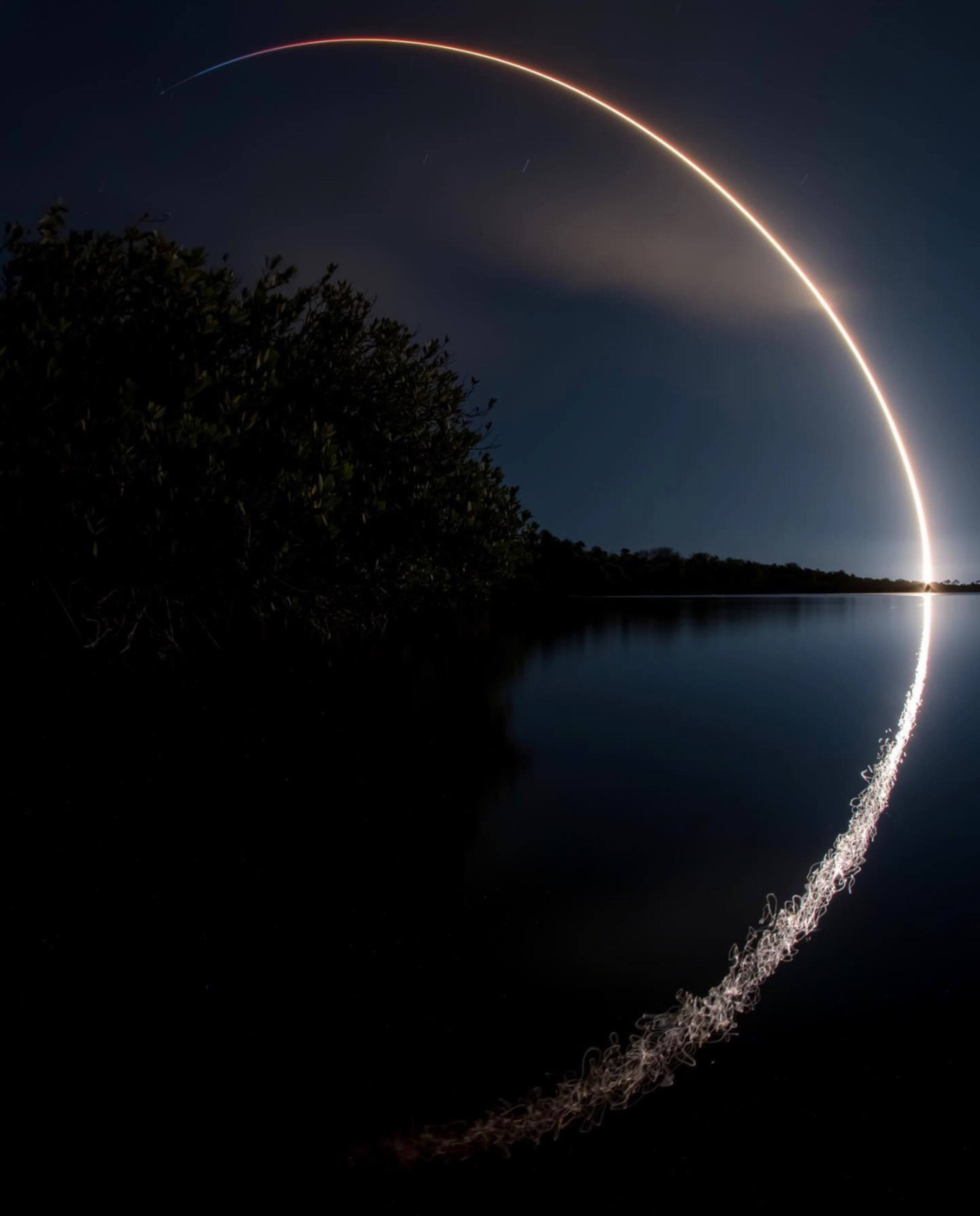 Long exposure rocket launch arc reflected in water, Cape Canaveral